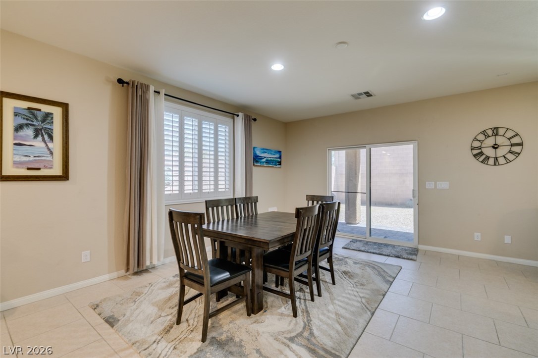 7375 Campbell Ranch Avenue Las Vegas, NV 89179 - Photo 16 of 45 A well-lit dining area featuring elegant tile flooring and convenient sliding glass doors leading outdoors.