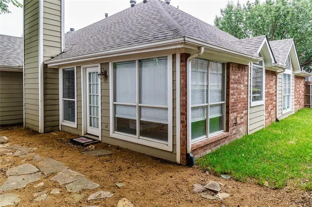 a view of a house with a large window and wooden fence