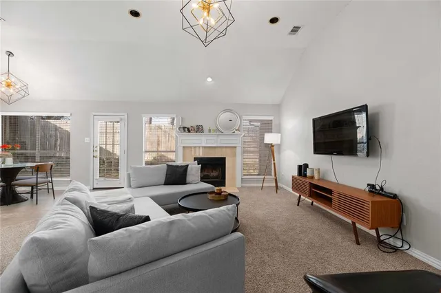 a living room with furniture a flat screen tv and a fireplace