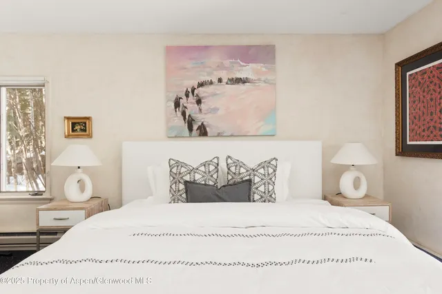 a spacious bedroom with a bed and a flat screen tv