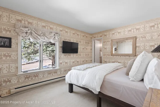 a bedroom with two beds and a large window