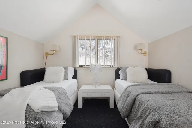 a bedroom with a bed a television and a large window