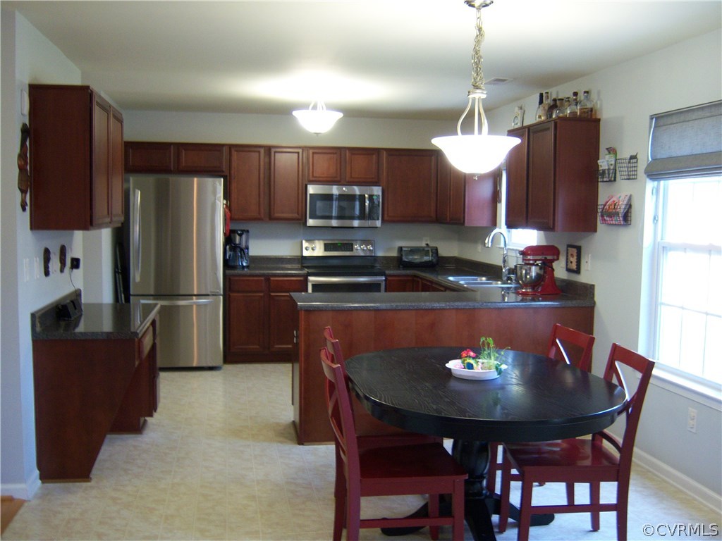 2115 Pemberton Road Henrico, VA 23238 - Photo 9 of 33 a kitchen with a refrigerator a stove a sink a dining table and chairs
