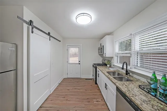 a kitchen with granite countertop a sink and cabinets
