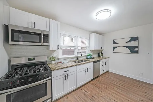 a kitchen with stainless steel appliances granite countertop a stove and a microwave