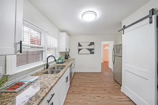 a kitchen with granite countertop a refrigerator and a sink