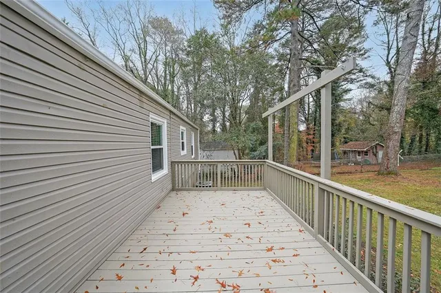 a view of a balcony with wooden floor and fence and a trees