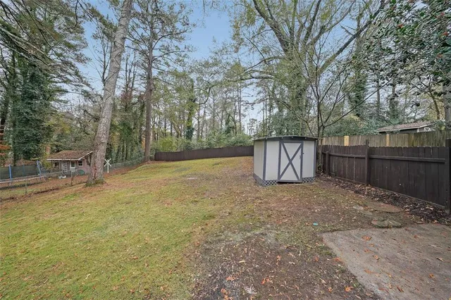 a view of backyard with tree and wooden fence