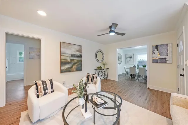 a living room with furniture a chandelier and a wooden floor