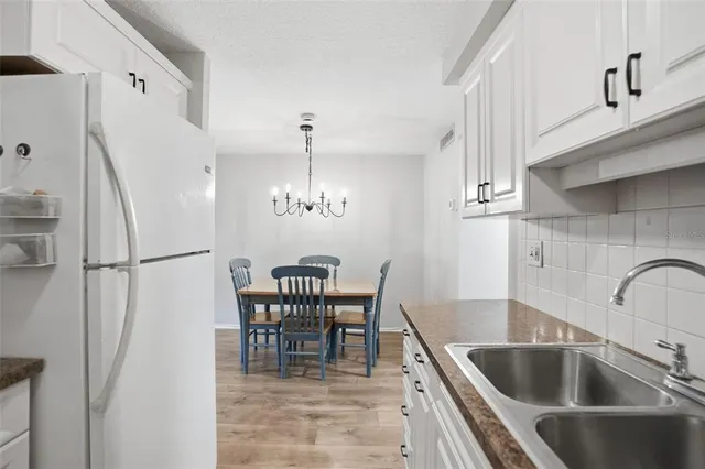 a kitchen with a table chairs and refrigerator
