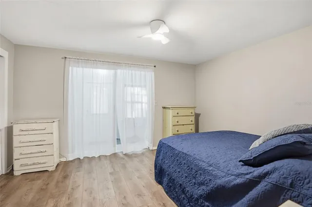 a bedroom with a bed a dresser and a window