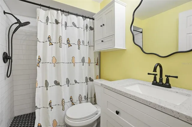 a bathroom with a sink mirror toilet and shower