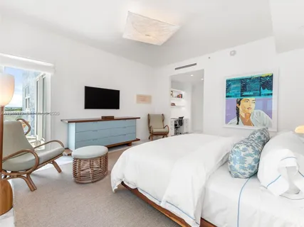 a spacious bedroom with a bed and a flat screen tv