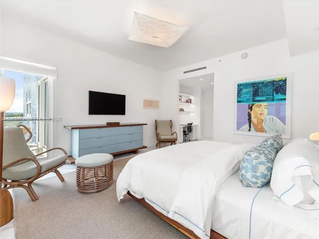 a spacious bedroom with a bed and a flat screen tv