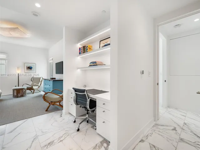 a view of a workspace with furniture and a window