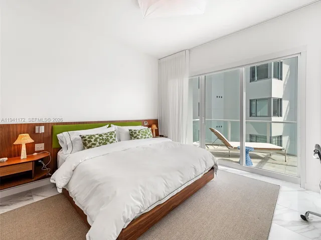 a bedroom with a bed and a large window