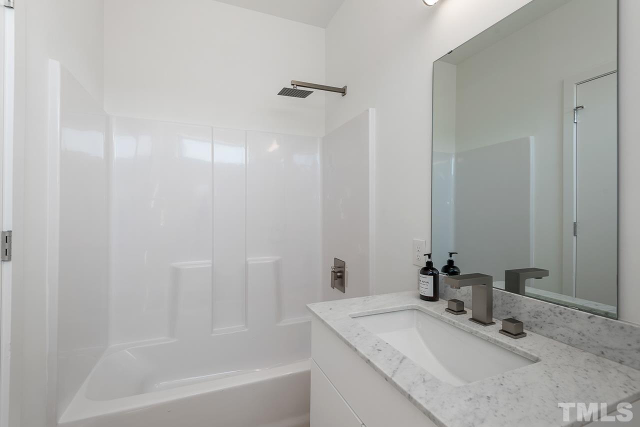 1115 Nova Street Durham, NC 27713 - Photo 53 of 56 a bathroom with a granite countertop sink a mirror and a bathtub