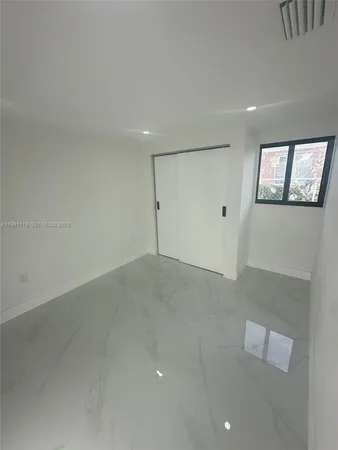 an empty room with windows and closet