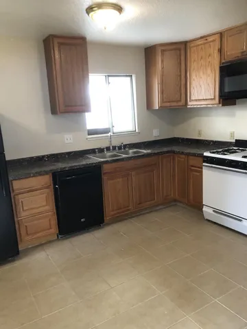 a kitchen with granite countertop stainless steel appliances a sink stove and microwave