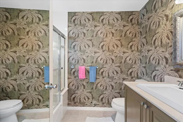 a bathroom with a granite countertop tub sink shower and mirror