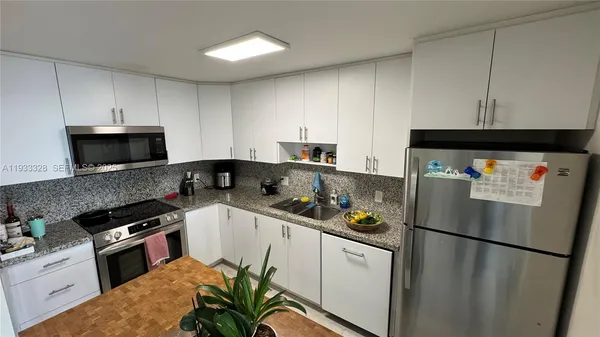 a kitchen with stainless steel appliances a refrigerator sink stove and cabinets