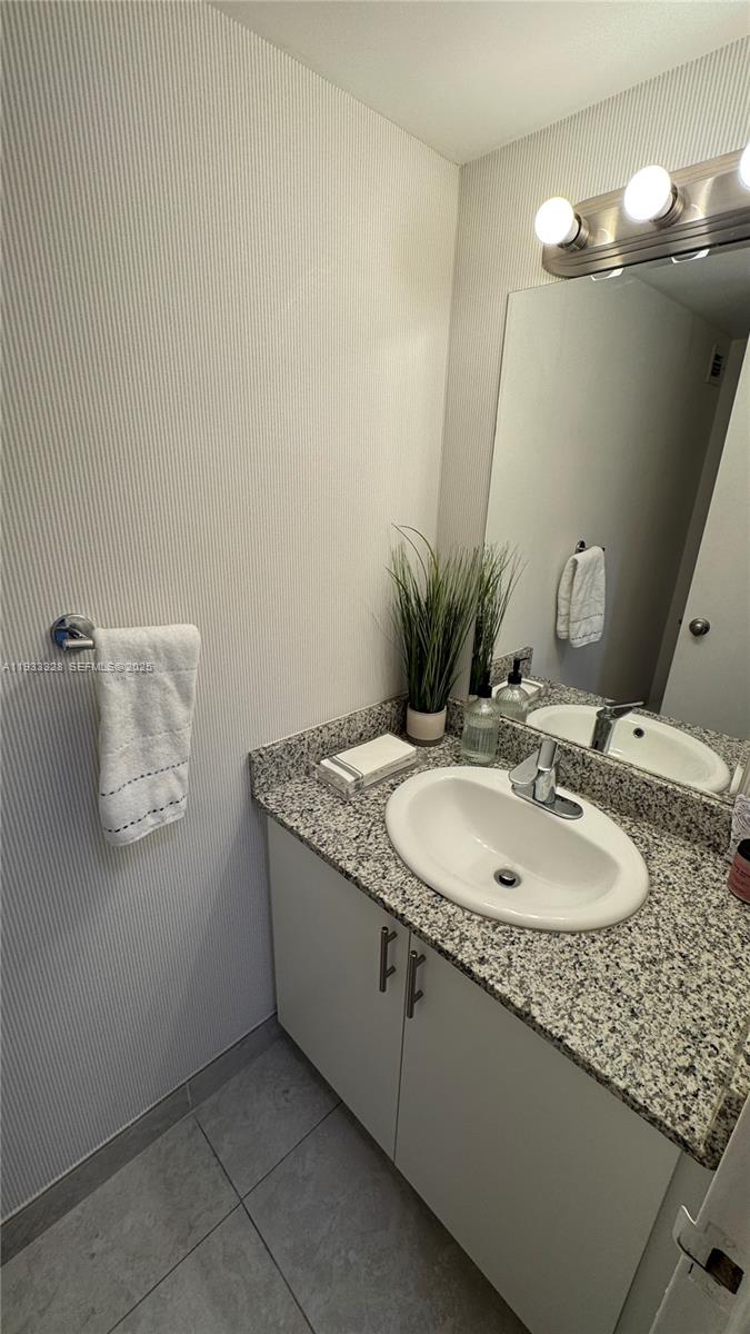 150 Southeast 25th Road, Unit 5L Miami, FL 33129 - Photo 3 of 9 a bathroom with a granite countertop sink and a mirror