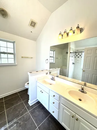 a spacious bathroom with a double vanity sink mirror and toilet