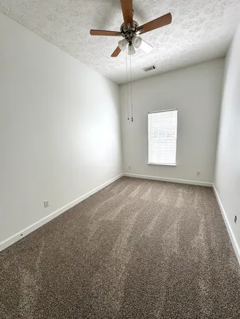 en empty room with windows and fan