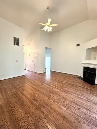 a view of empty room with wooden floor and fireplace