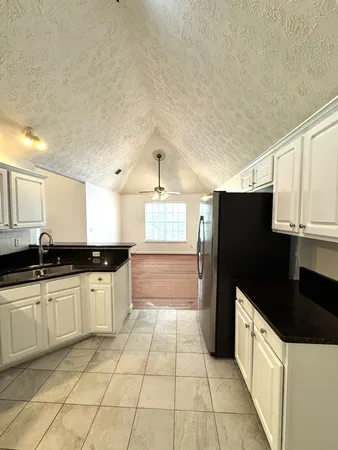 a large kitchen with granite countertop a stove a sink dishwasher and a refrigerator