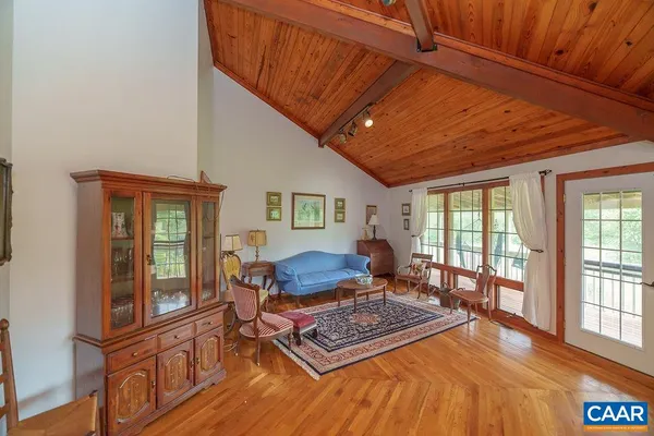 a dining room with wooden floor a glass table and chairs