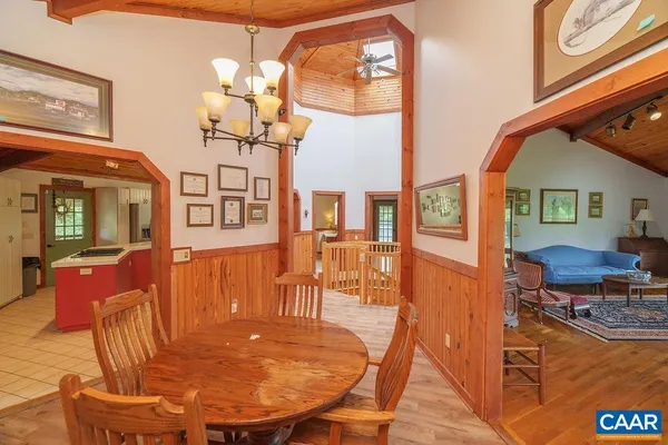 a dining room with furniture a chandelier and wooden floor