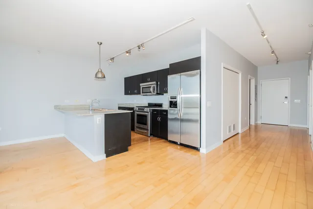 a view of a kitchen with stainless steel appliances granite countertop a sink and cabinets
