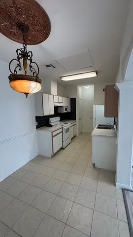 a kitchen with stainless steel appliances a sink a stove a microwave a counter top space and cabinets