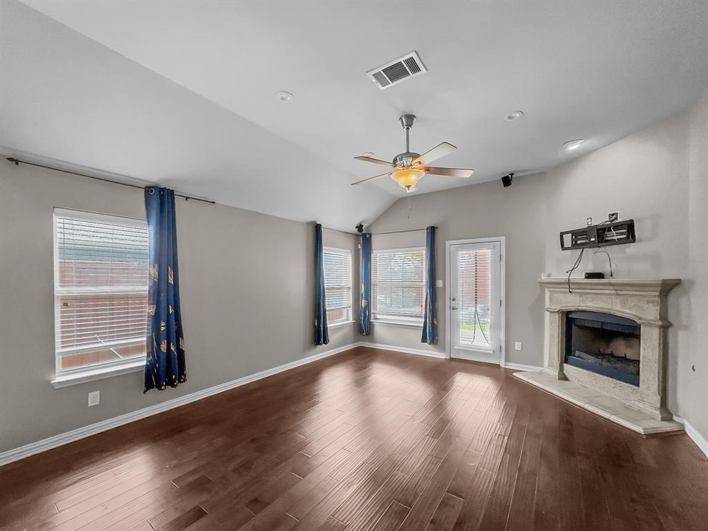 3205 Ridgeway Drive McKinney, TX 75071 - Photo 6 of 27 a view of an empty room with wooden floor fireplace and a window