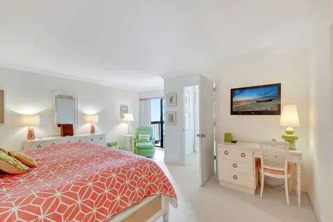 a bedroom with a bed and a flat tv screen on dresser