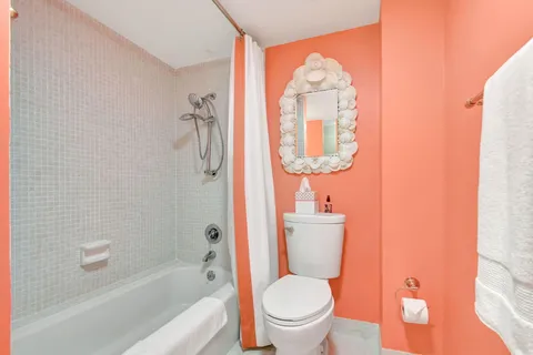 a white toilet sitting next to a bathtub