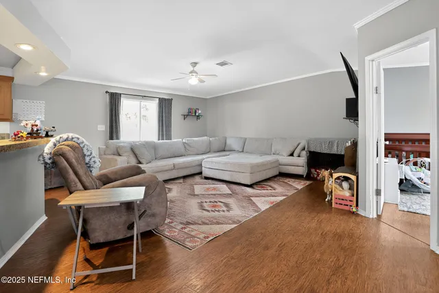a living room with furniture and a wooden floor