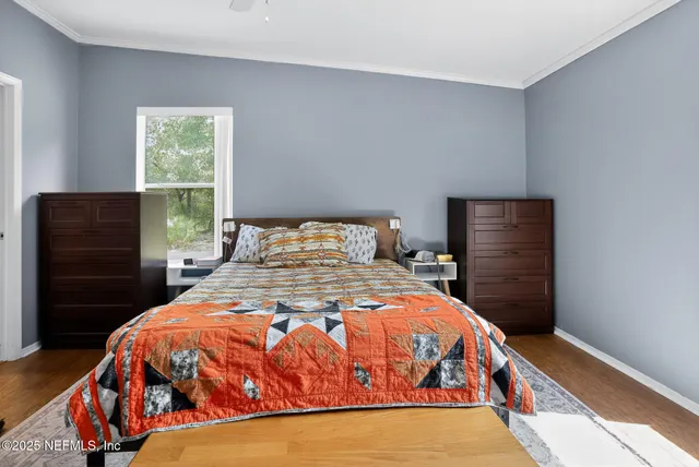 a bedroom with a bed and wooden floor