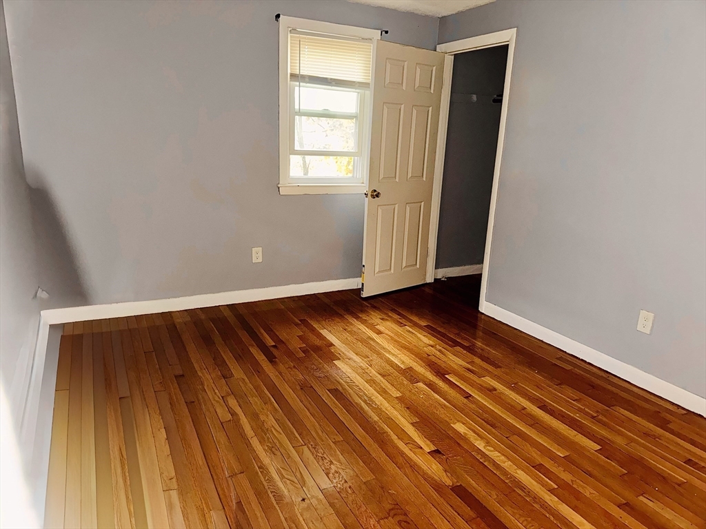 6 A Maynard Street, Unit A Boston, MA 02131 - Photo 2 of 12 an empty room with wooden floor and windows