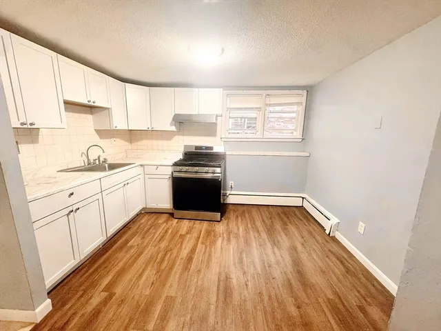 a kitchen with wooden floors and white appliances