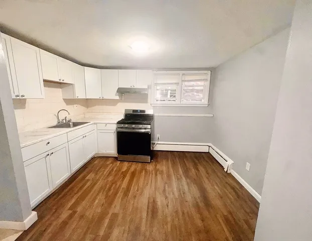 a kitchen with wooden floors and white appliances