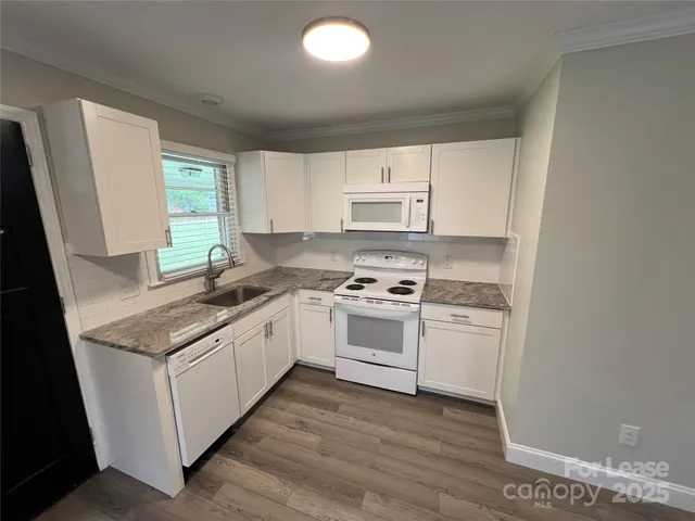 a kitchen with stainless steel appliances granite countertop a sink stove and a refrigerator