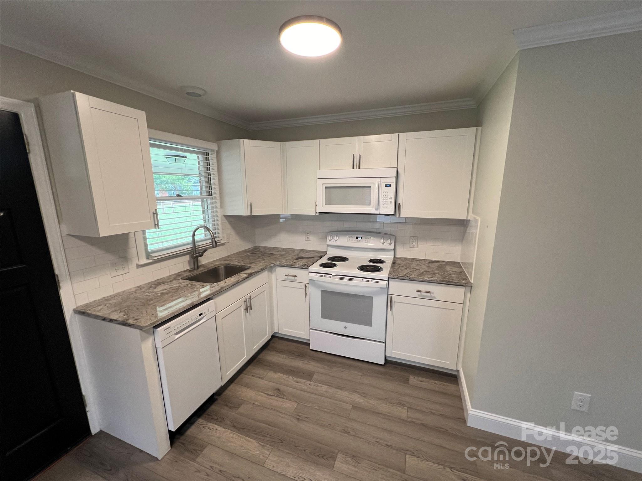 104 Secrest Avenue Belmont, NC 28012 - Photo 2 of 10 a kitchen with stainless steel appliances granite countertop a sink stove and a refrigerator