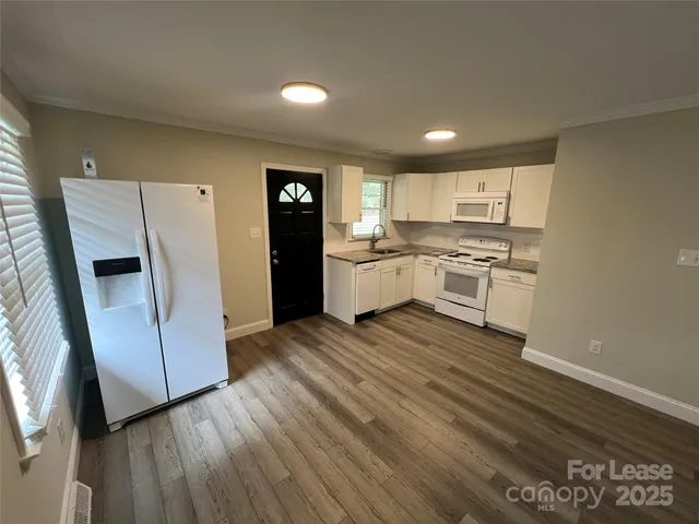 a kitchen with a refrigerator and a stove top oven
