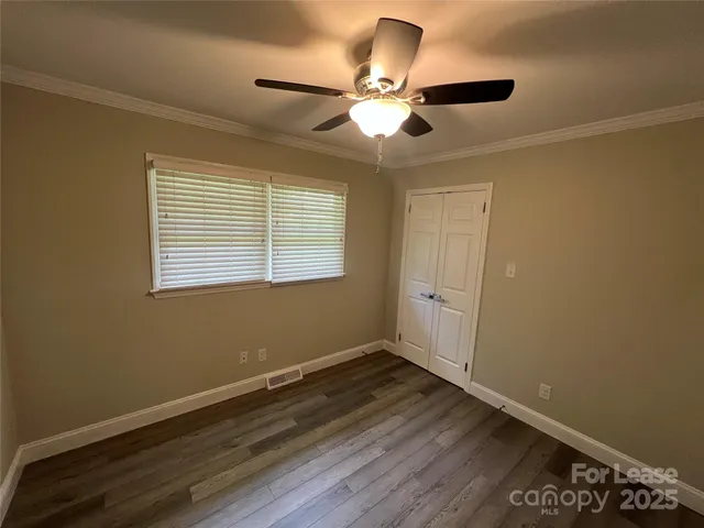 a view of a room with wooden floor and windows
