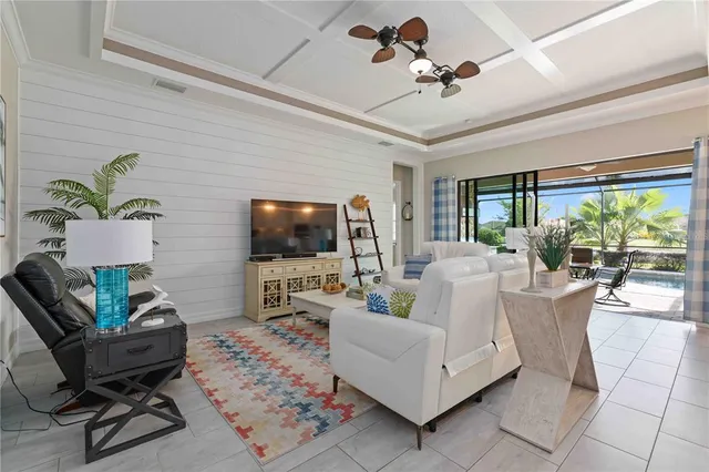 a living room with furniture a flat screen tv and a large window