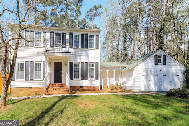 a view of a white house with a big yard and large trees