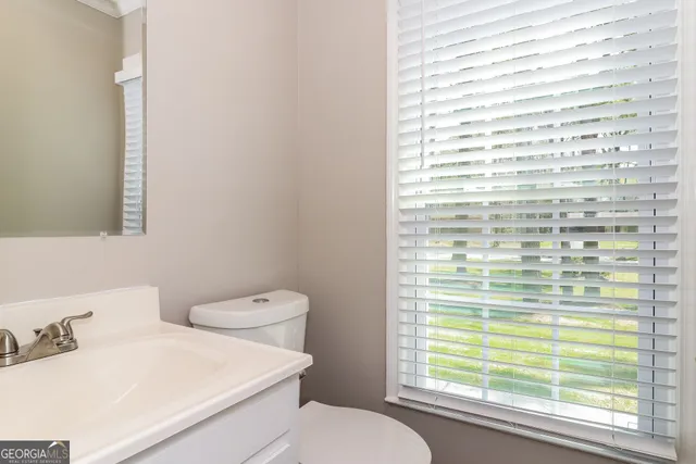 a bathroom with a toilet a sink and a window
