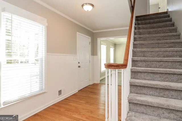 a view of a hallway with wooden floor and staircase